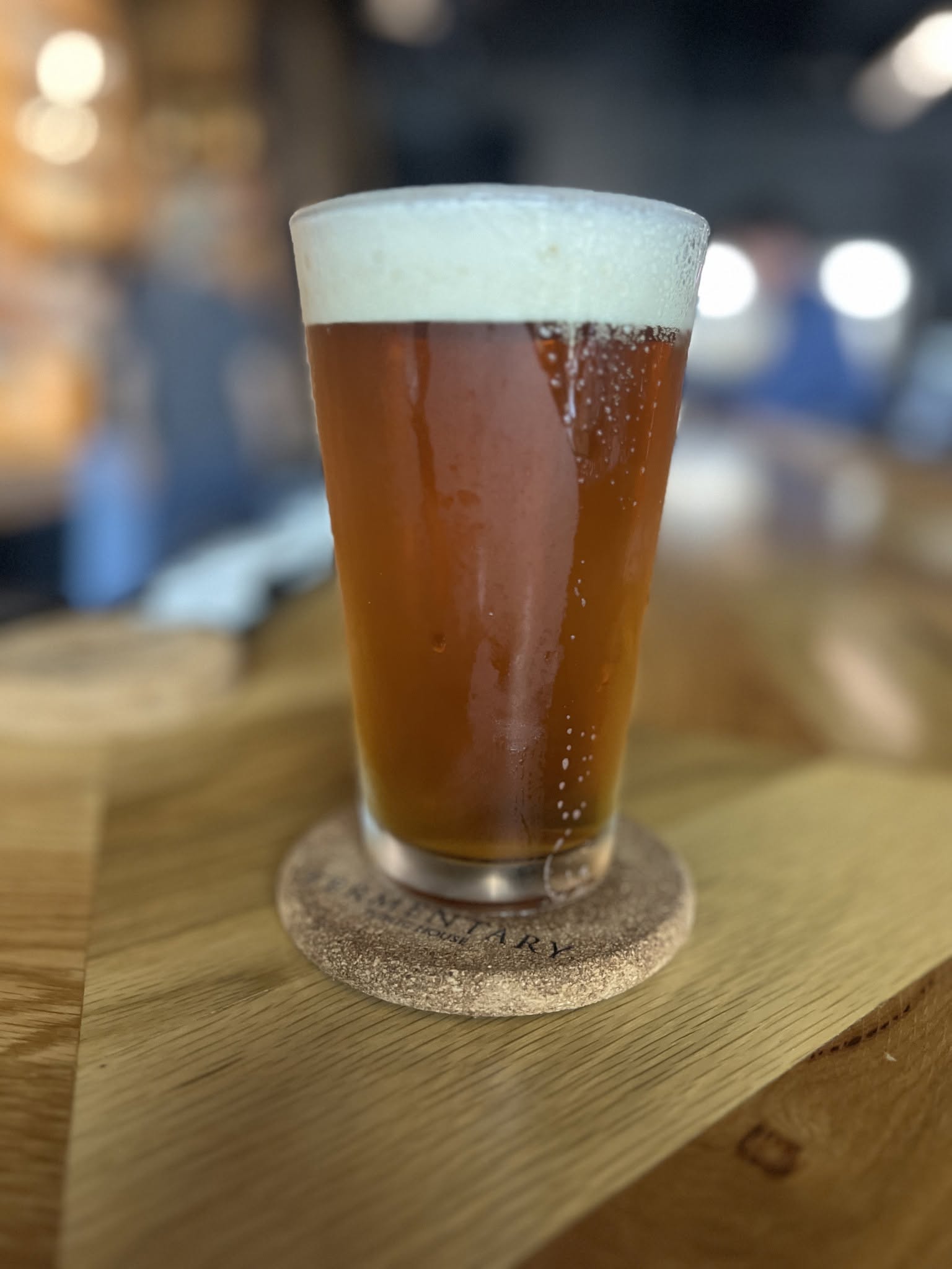 An amber house ale on a Fermentary cork coaster.