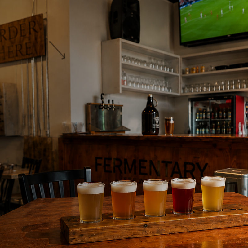 A flight of five house beers on a paddle.